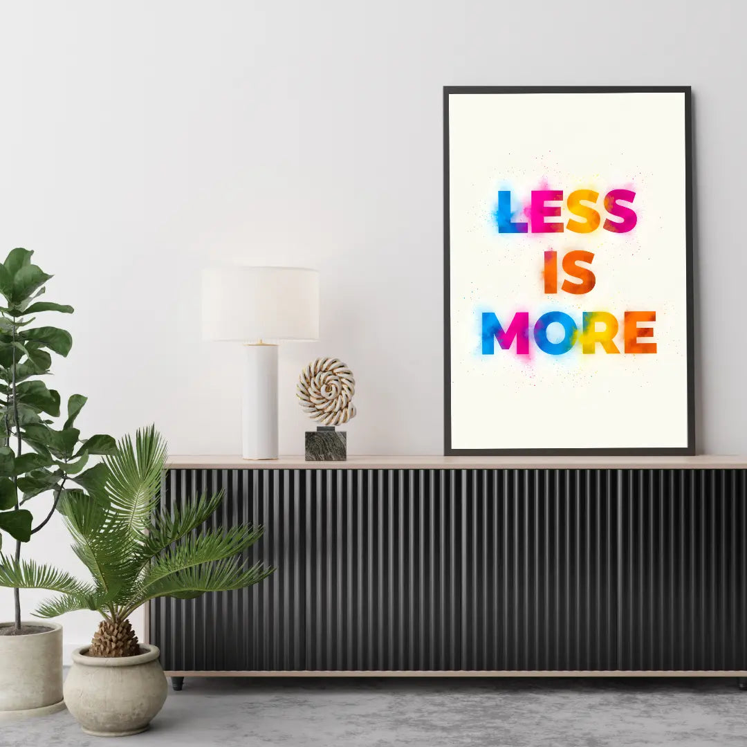 ForWalls.eu - Plakat Less Is More - Minimalist poster with colorful "LESS IS MORE" typographic text on white background in black frame on sideboard. - minimalistyczny, plakat, typografia